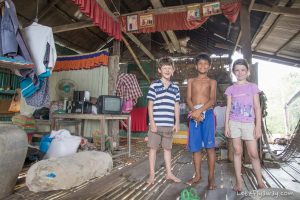western kids with their cambodian friend in the floating village of Kamphong Phluk